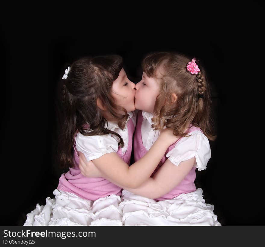 Adorable twins embracing on black