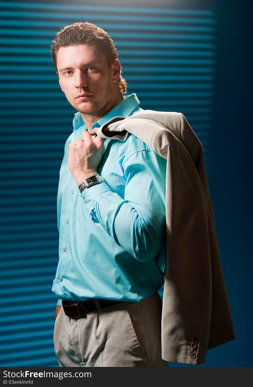 Business man in a suit standing near the wall, still photos