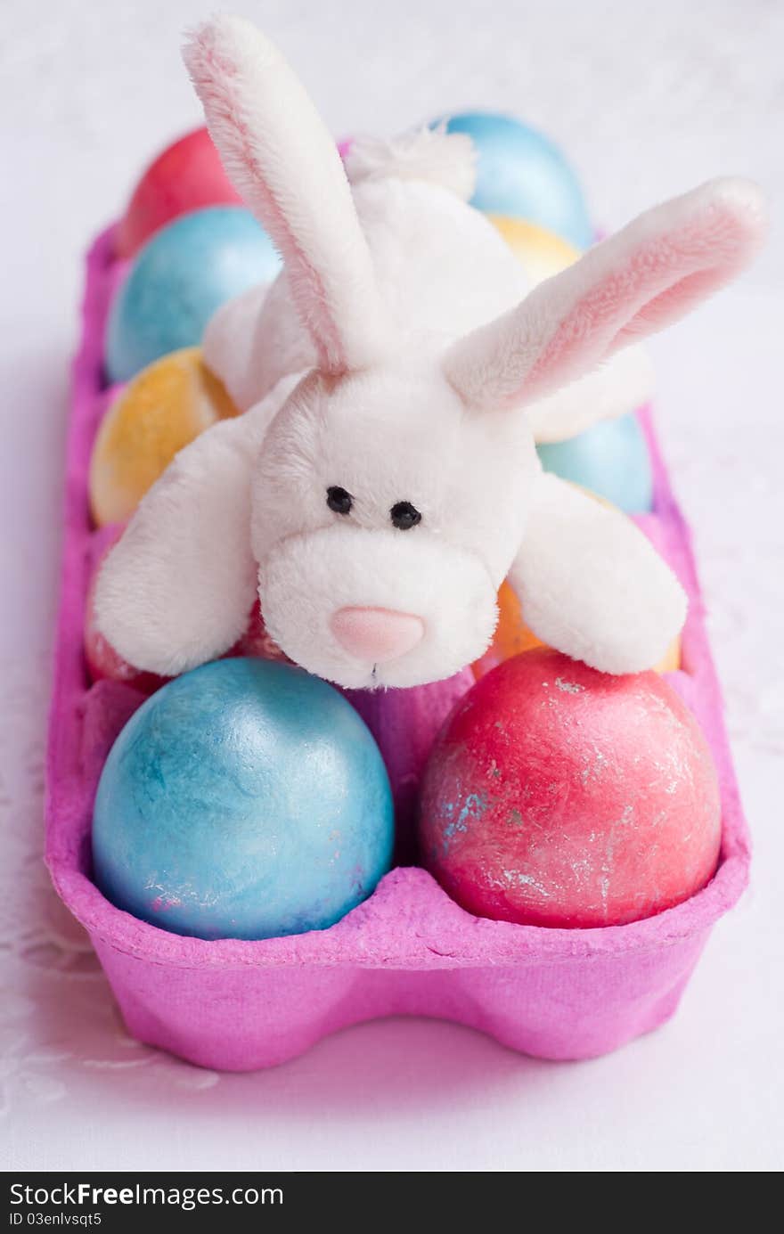 Multicolored shiny easter eggs and funny rabbit, selective focus. Multicolored shiny easter eggs and funny rabbit, selective focus.