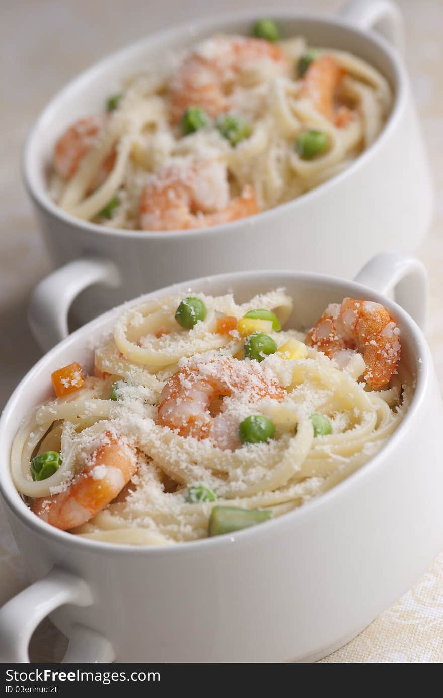 Lemony prawn and pea pasta topped with grated cheese. Lemony prawn and pea pasta topped with grated cheese