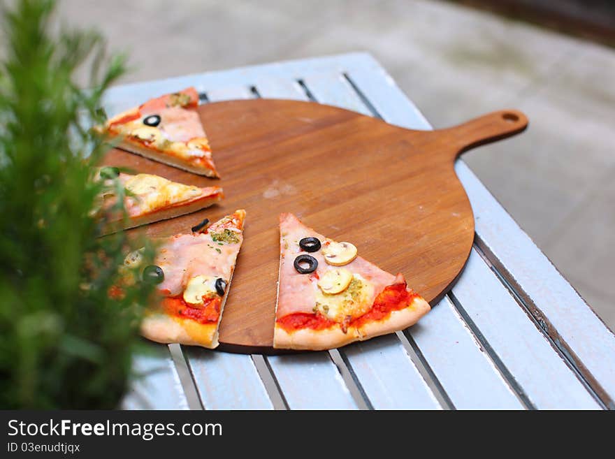 Pizza Sliced On The Wooden Board