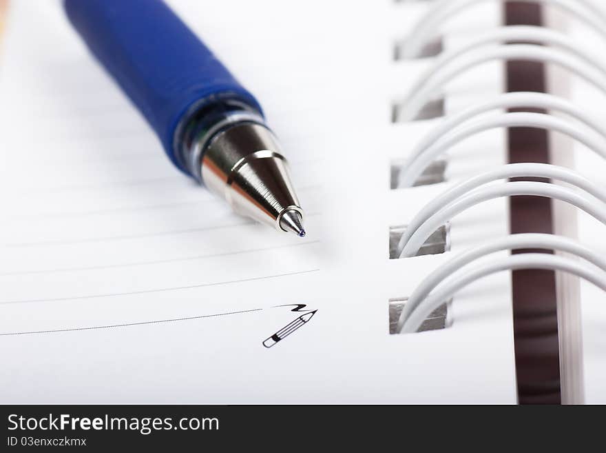 Macro view of blank spiral notebook and pen