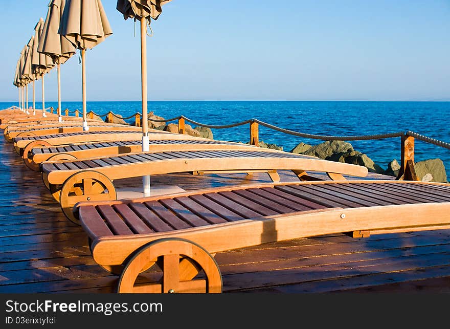 Sun loungers on a beach with a parasol.