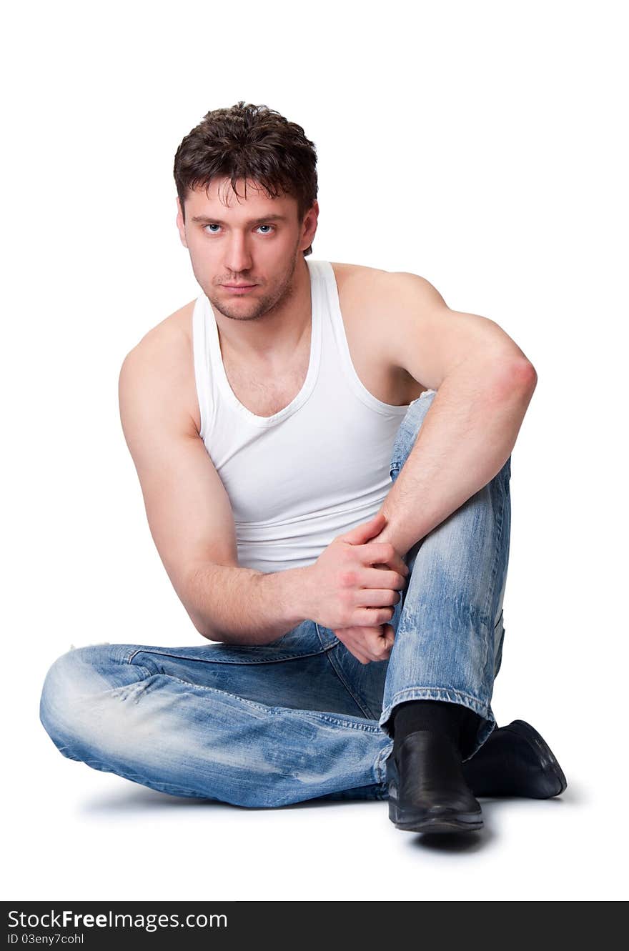 Man In Jeans Sitting On An Isolated Background