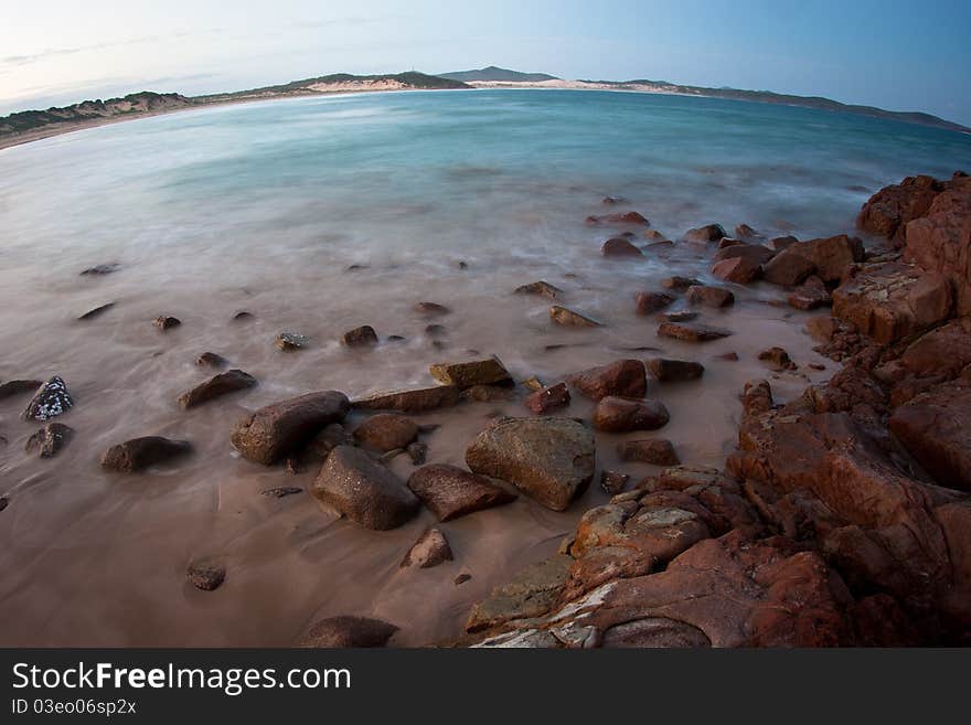 A slow exposure of waves breaking onto rocks with a beach, taken with a wide angle lense to give and interesting effect. A slow exposure of waves breaking onto rocks with a beach, taken with a wide angle lense to give and interesting effect.