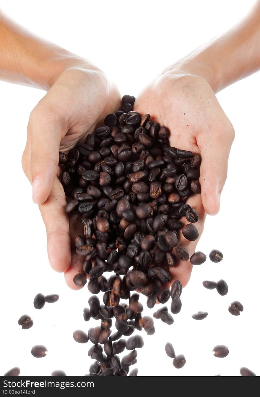 Hand pouring a bunch of black coffee beans