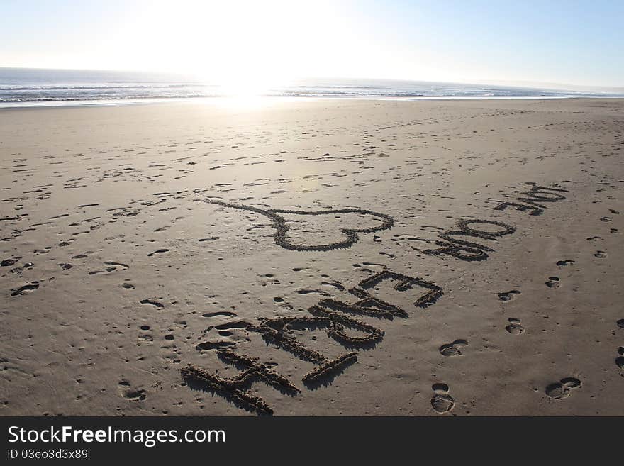 Love Our Earth Sketched into the Sand at the Beach near the Ocean