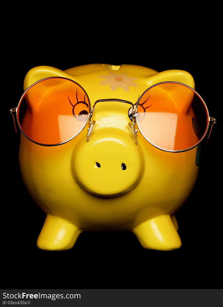 Yellow piggybank with sunglasses