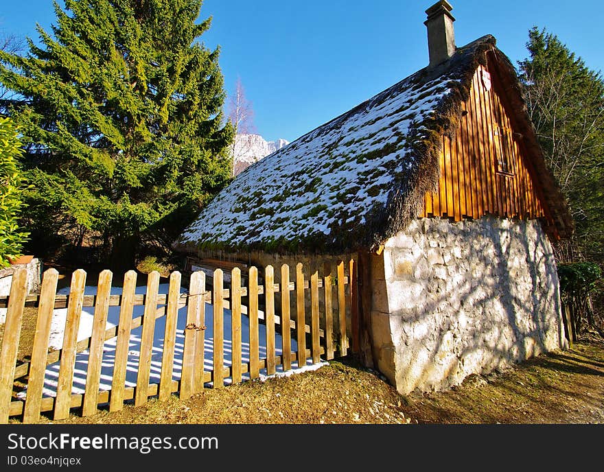 Typical country house with a thathed roof in chartreuse park in french alps in winter