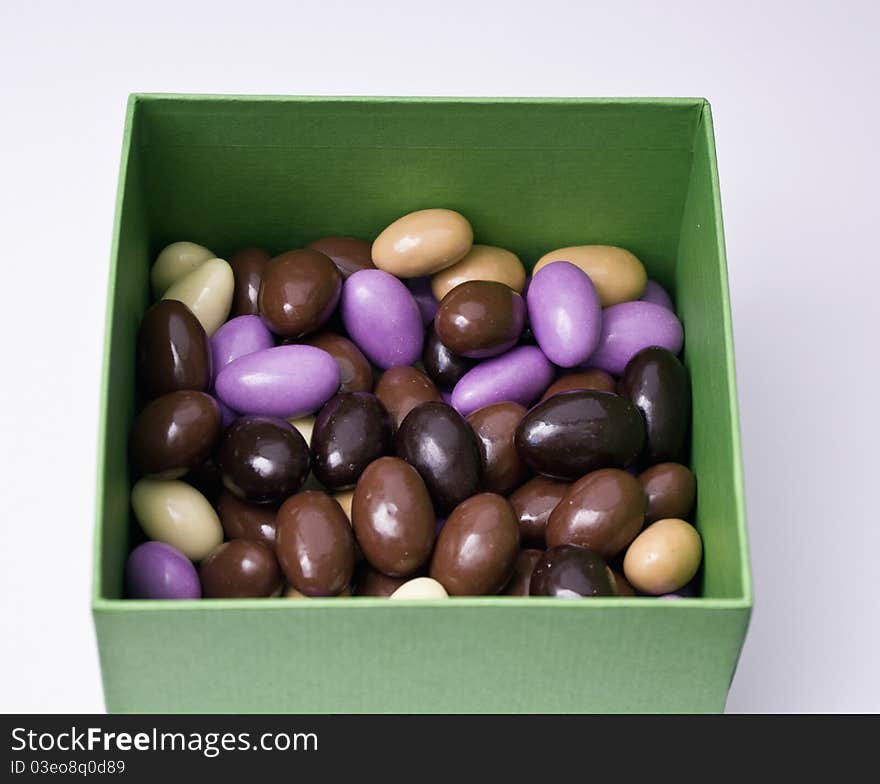 Chocolate almonds with diferent colors in a green box