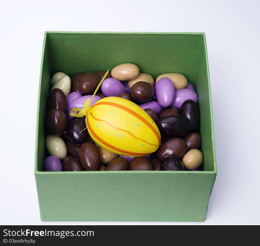 Chocolate almonds with diferent colors in a green box