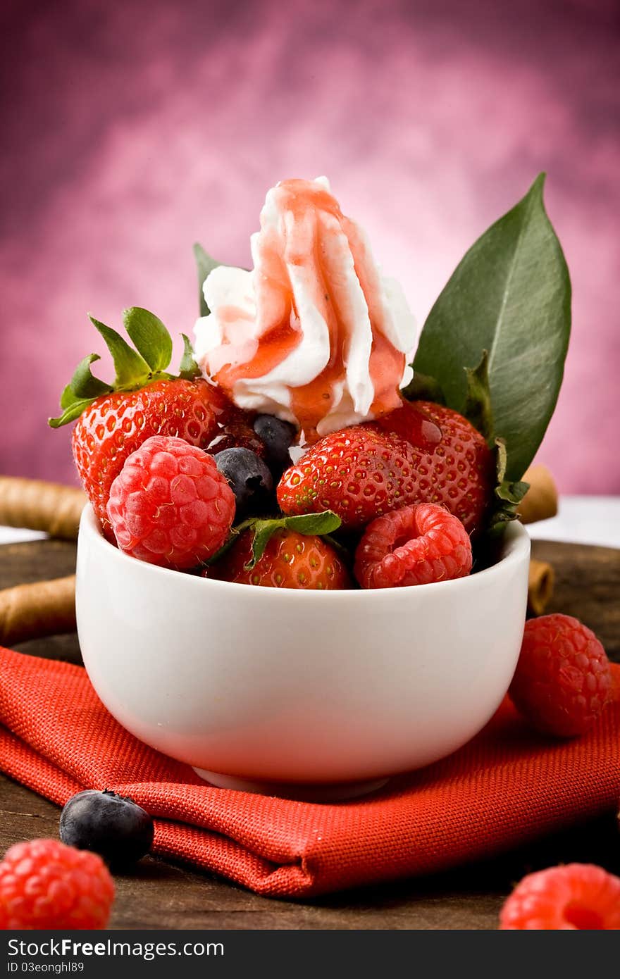 Photo of berries inside a white bowl on wooden table