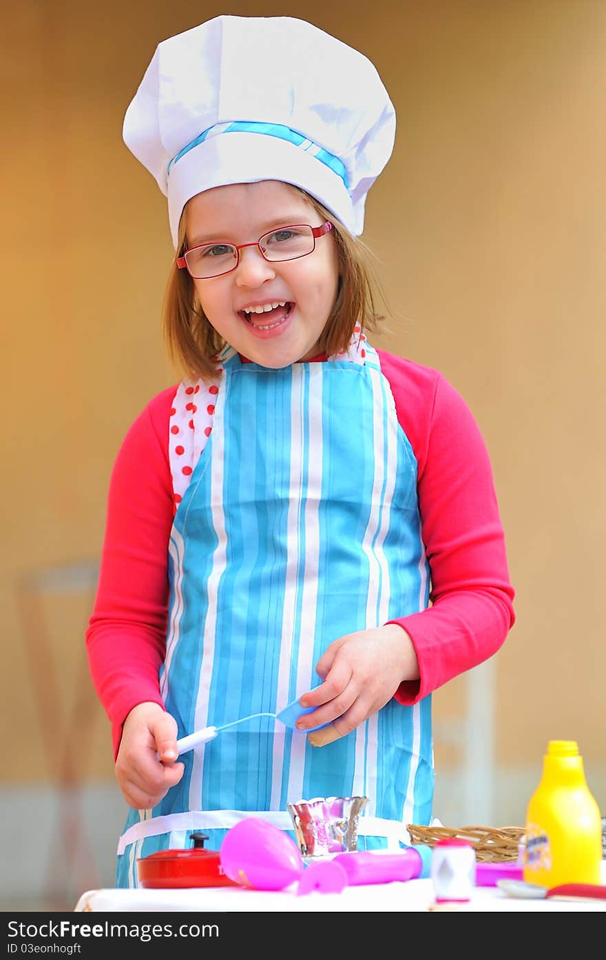 Little girl having fun playing cooking