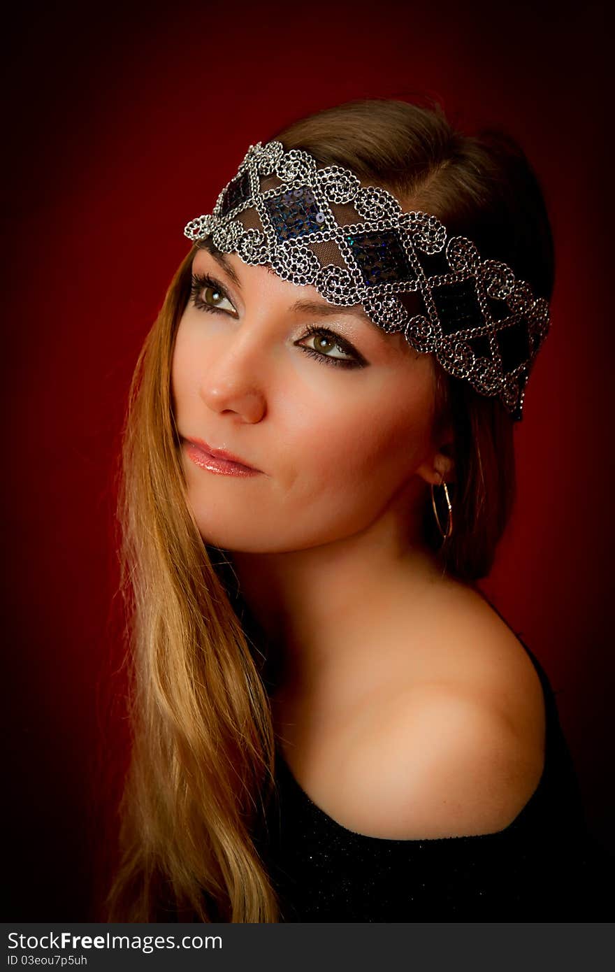 Girl with a national ornament on long hair on a red background. Girl with a national ornament on long hair on a red background