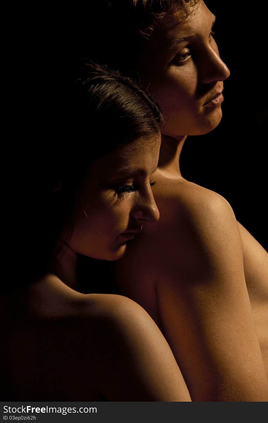 Profile of young Couple Dramatic image shot in studio, on dark. Profile of young Couple Dramatic image shot in studio, on dark