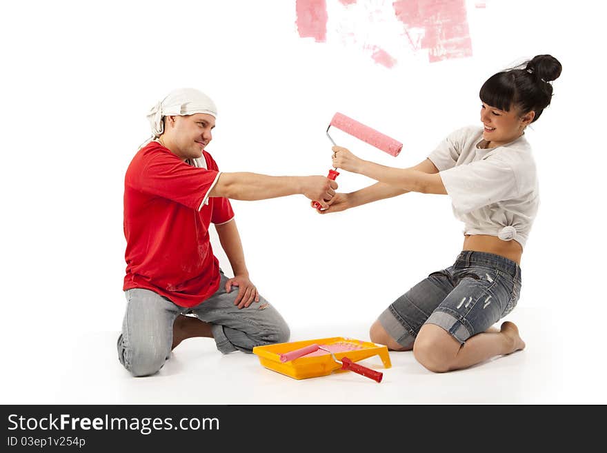 Cheerful young couple of workers preparing to painting a wall