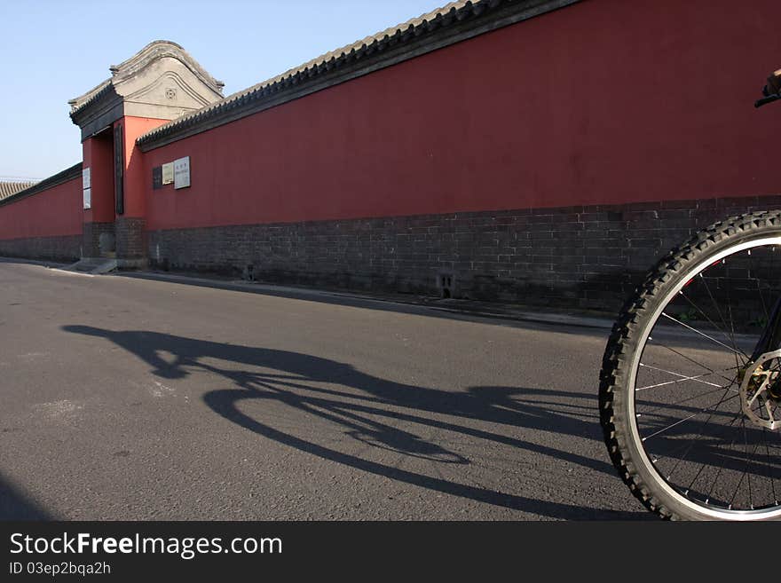 Riding bicycle along the red wall in the morning