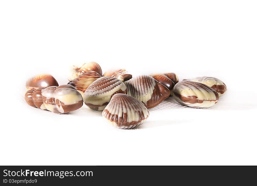 Sea shell Belgium traditional chocolate candies on white napkn. Sea shell Belgium traditional chocolate candies on white napkn.