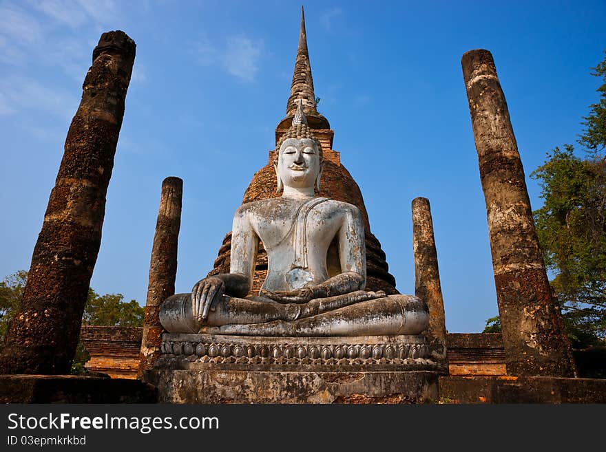 Seated buddha and brick stupa amidst the ruins of an ancient temple in Sukhothai Historical Park, Thailand. Asia. Seated buddha and brick stupa amidst the ruins of an ancient temple in Sukhothai Historical Park, Thailand. Asia.