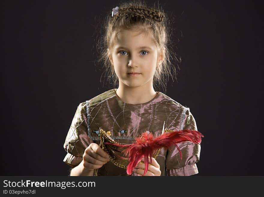 Little pretty blue-eyed girl holding beautiful mask. Little pretty blue-eyed girl holding beautiful mask