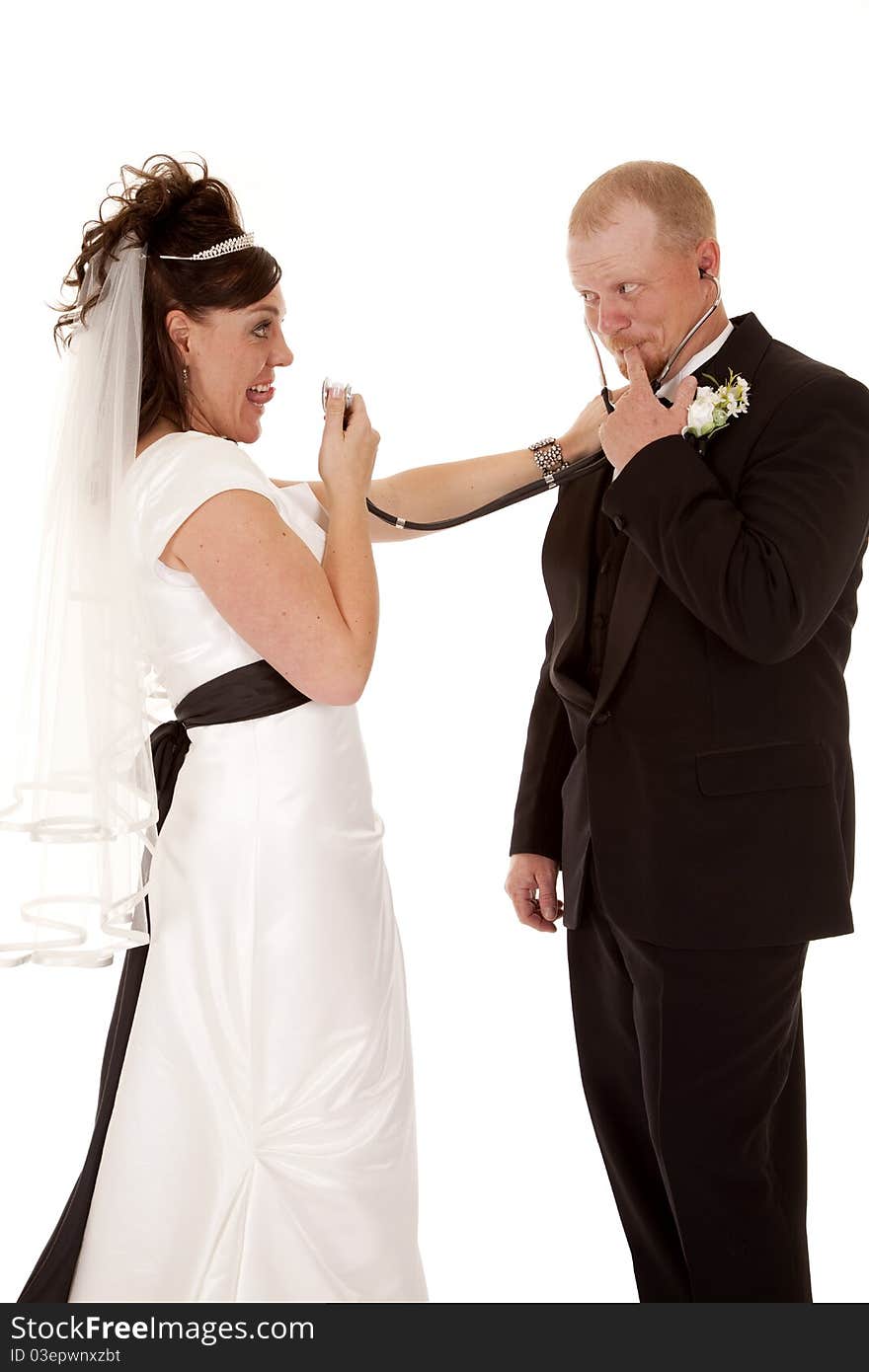 A bride flirting with her groom by playing doctor and talking into her stethoscope. A bride flirting with her groom by playing doctor and talking into her stethoscope.