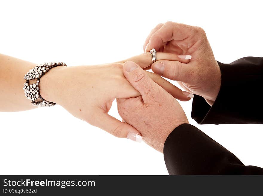 A close up of a groom giving his bride her wedding ring. A close up of a groom giving his bride her wedding ring.