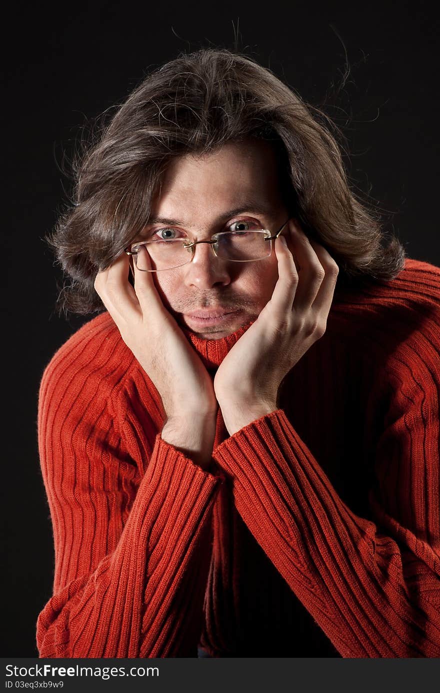 Man with log hair in red sweater and glasses.