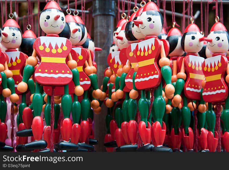 Images shows a bundle of some colourful wooden puppets. Colours dominating the picture are red and green.