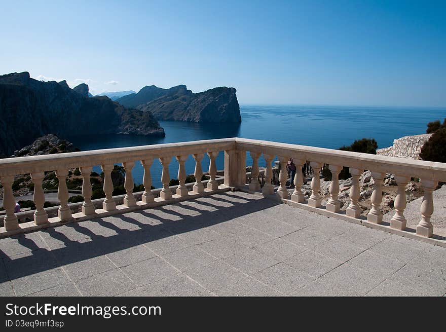 Image shows a scenery of Formentor, Majorca, Spain. A stone view point in the middle, steel coast on the left and blue sea on the right. Above blue sky. Image shows a scenery of Formentor, Majorca, Spain. A stone view point in the middle, steel coast on the left and blue sea on the right. Above blue sky.