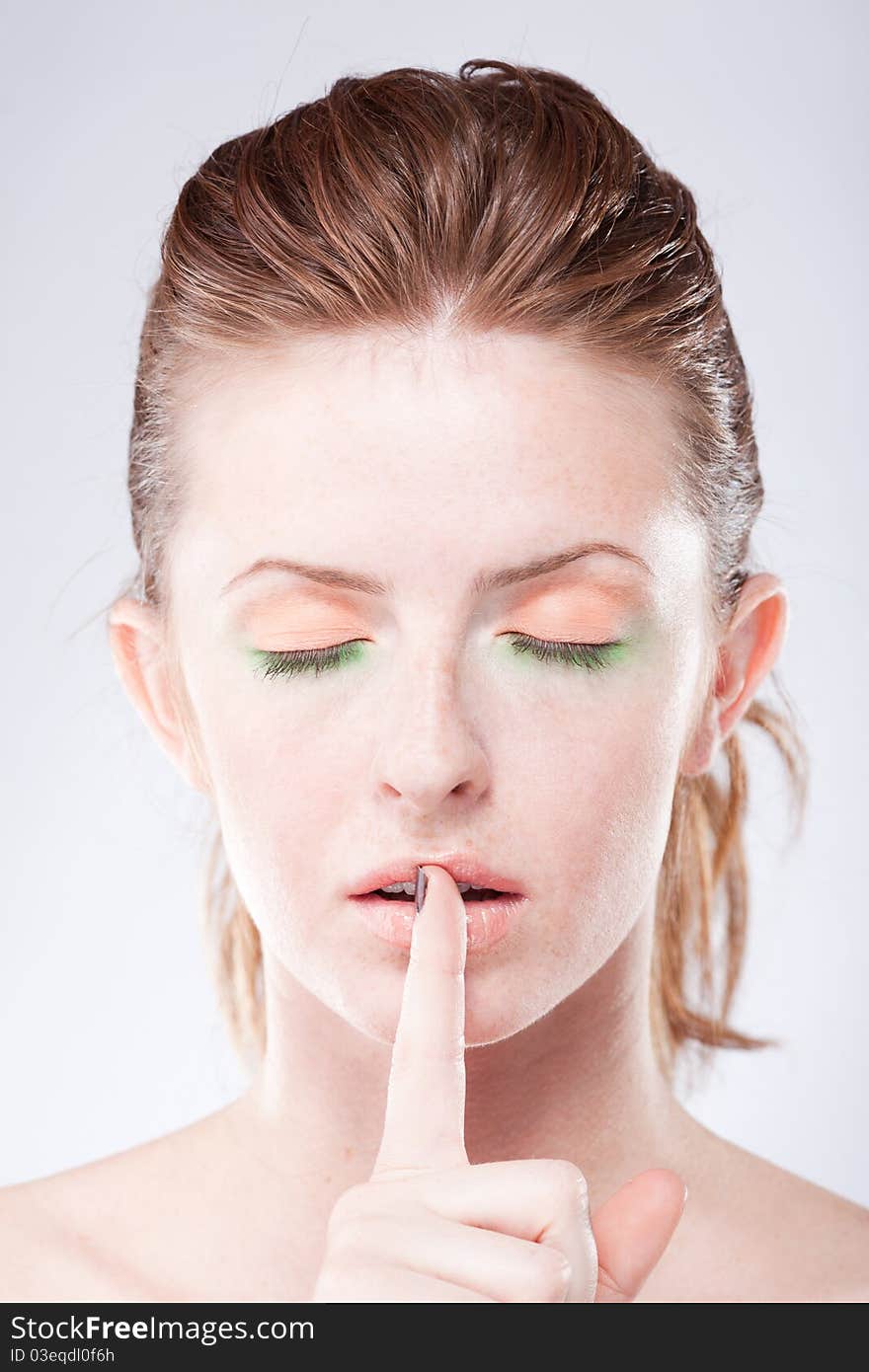 Red hair woman make quiet gesture with closed eyes