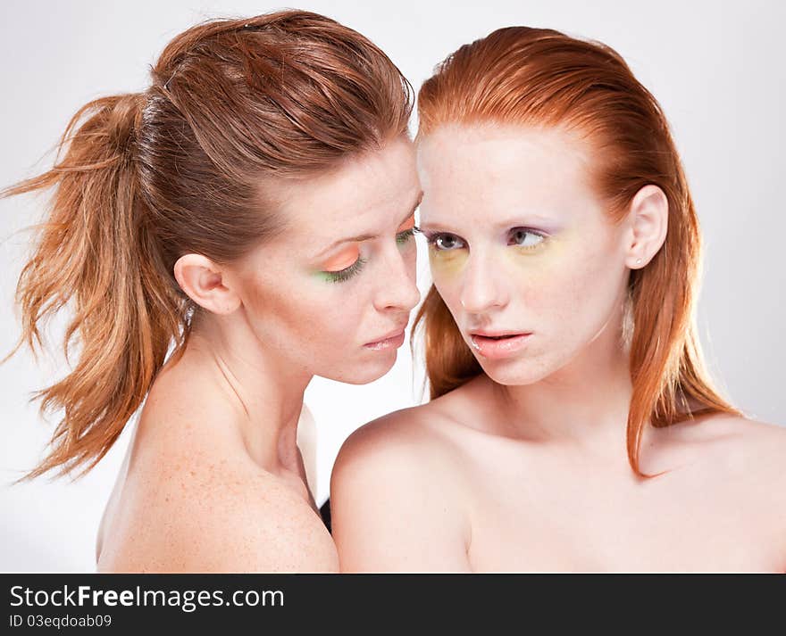 Two red-haired beautiful woman sensually look at each other