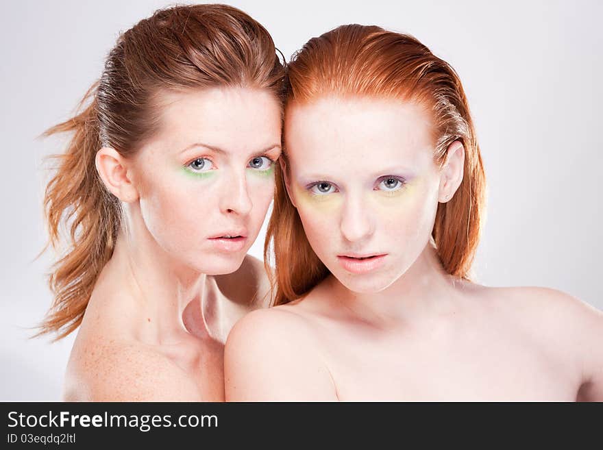 Two red-haired beautiful woman looking at camera