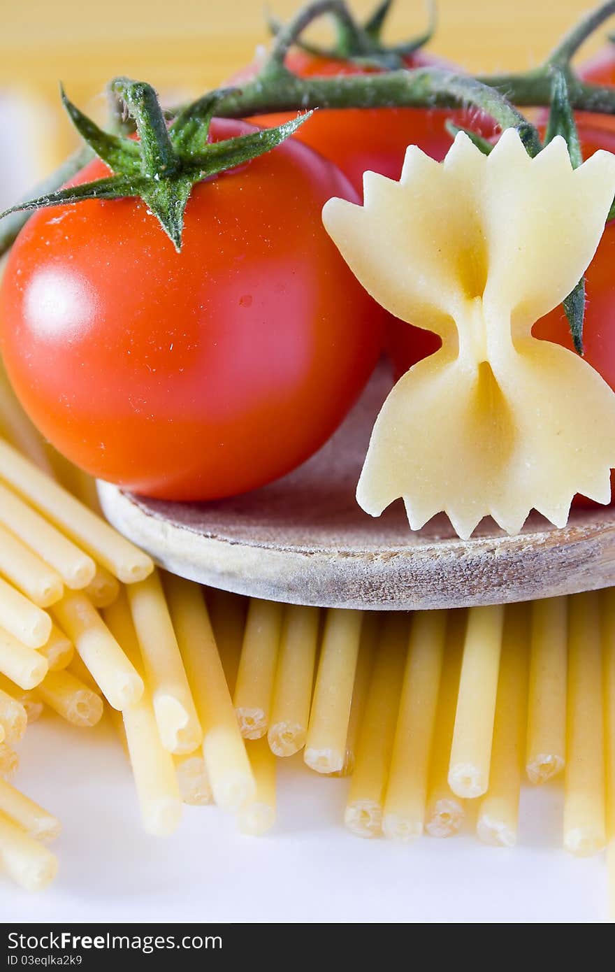 Butterfly pasta with tomato and basil on spoon. Butterfly pasta with tomato and basil on spoon