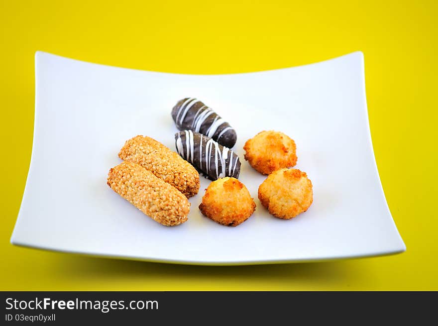 Easter baking on a flat white plate on a yellow background. Easter baking on a flat white plate on a yellow background