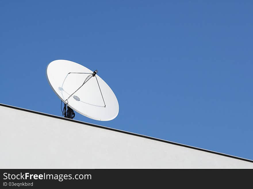 The satellite dish on the roof building.