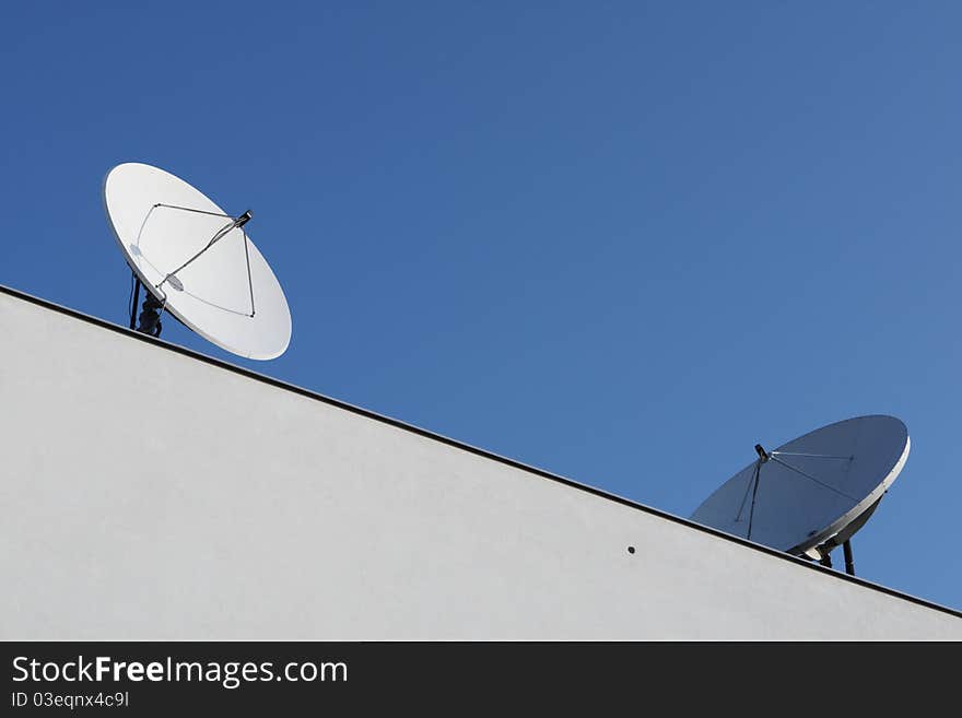 The satellite dish on the roof building.