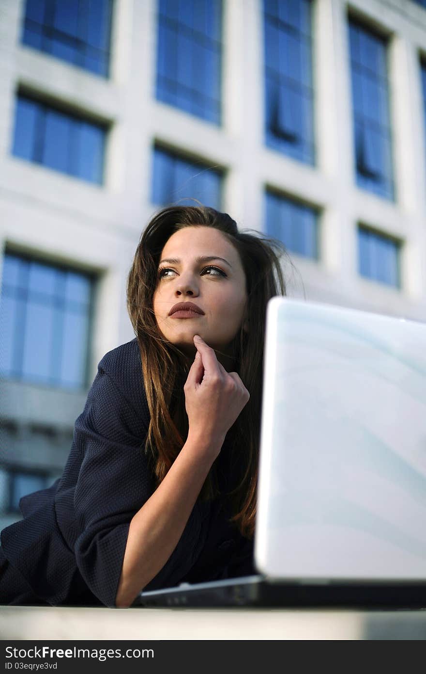 Beautiful young female working on laptop outside. Beautiful young female working on laptop outside