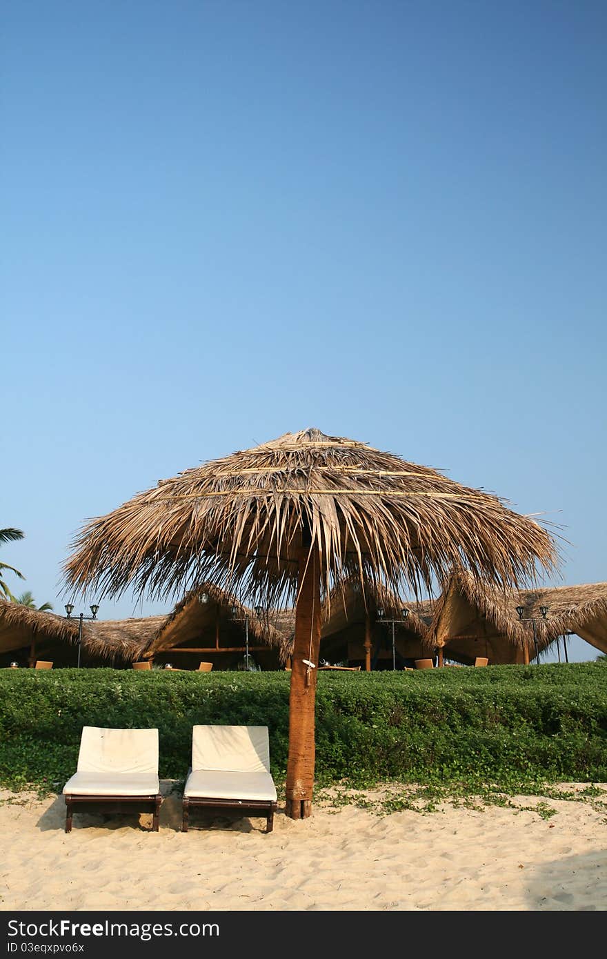 Two seats at tropical country with umbrella on the beach. Two seats at tropical country with umbrella on the beach