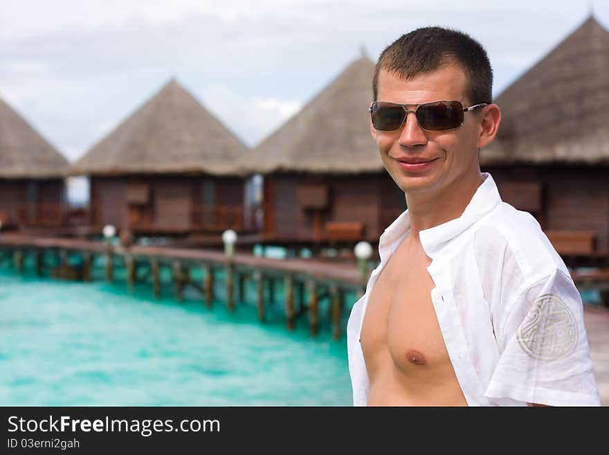 Man is in white on a pier. Man is in white on a pier