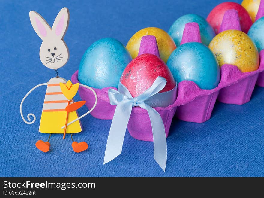 Easter: box with multicolored eggs and funny bunny. Easter: box with multicolored eggs and funny bunny.