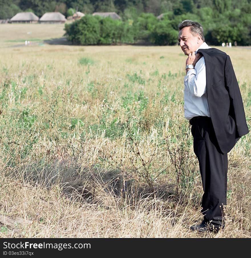 Man with suite stands in the field. Man with suite stands in the field