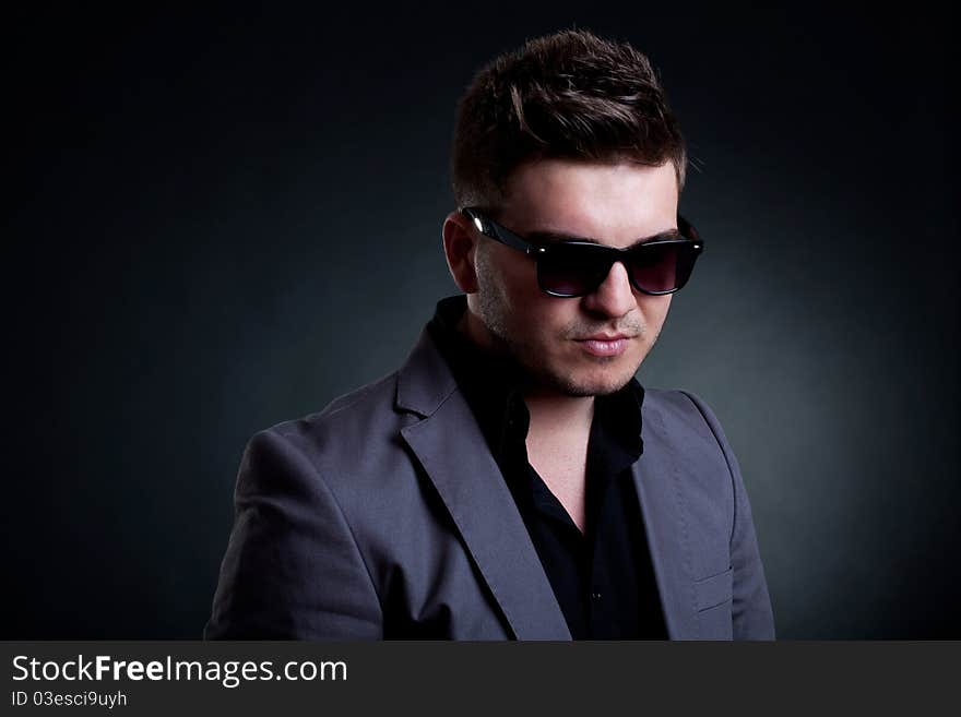 Portrait of young handsome man with sunglasses , over dark background