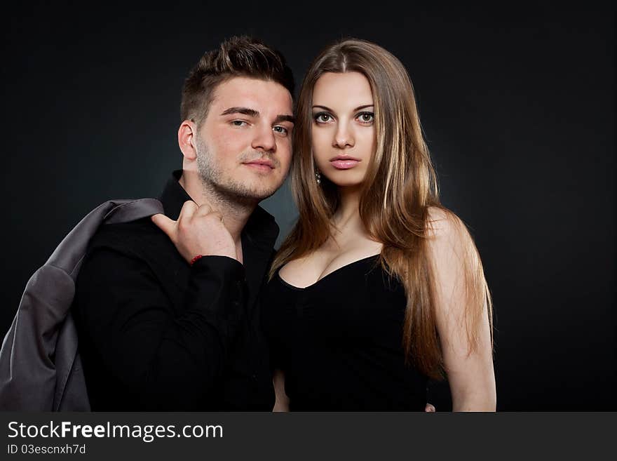 Picture of a young couple standing next to each other on black