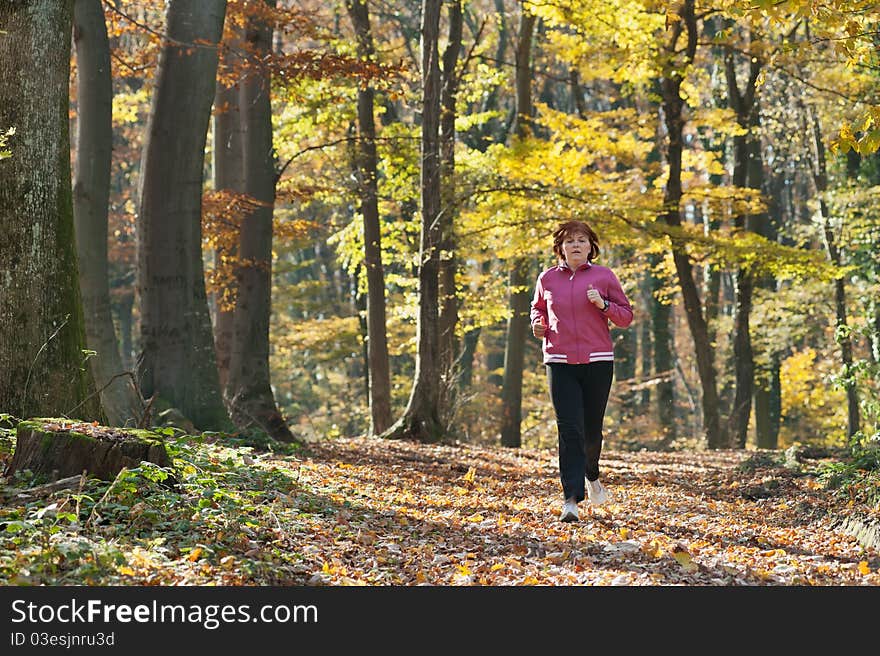 Middle age woman jogging in the forest