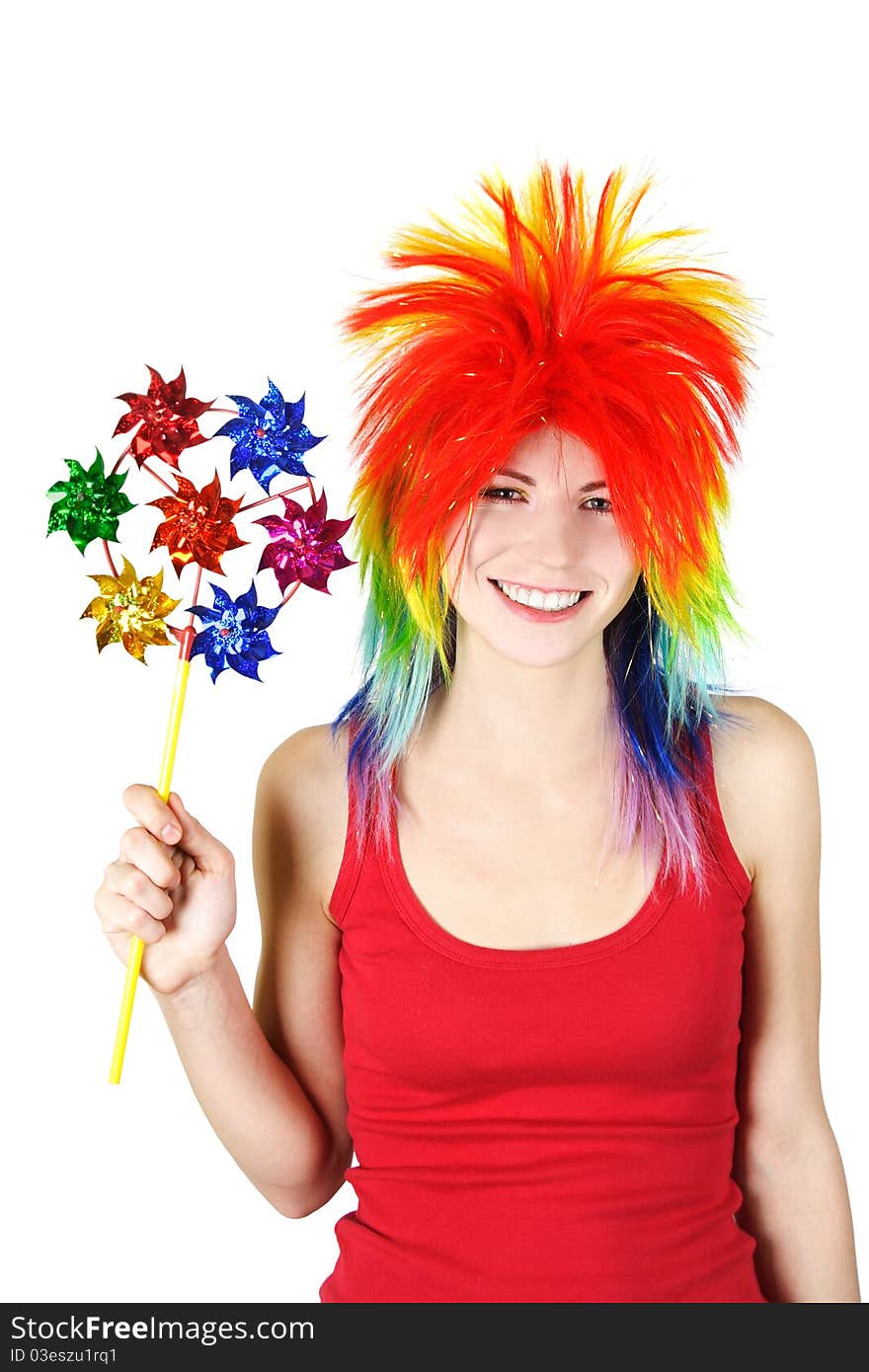 Young beauty woman in multicolored clown wig smiling and holding pinwheel, isolated. Young beauty woman in multicolored clown wig smiling and holding pinwheel, isolated