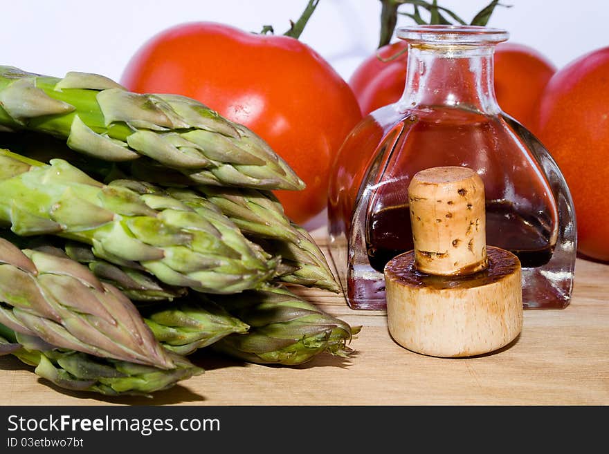 Closeup of cork, little bottle, green asparagus, red tomato. Closeup of cork, little bottle, green asparagus, red tomato