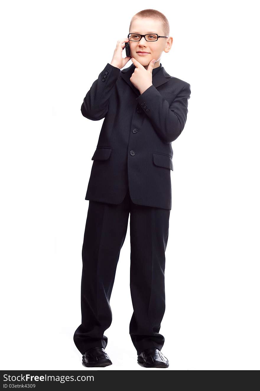 Ten year old blond boy wearing a costume talking on the cellphone, isolated against white. Ten year old blond boy wearing a costume talking on the cellphone, isolated against white