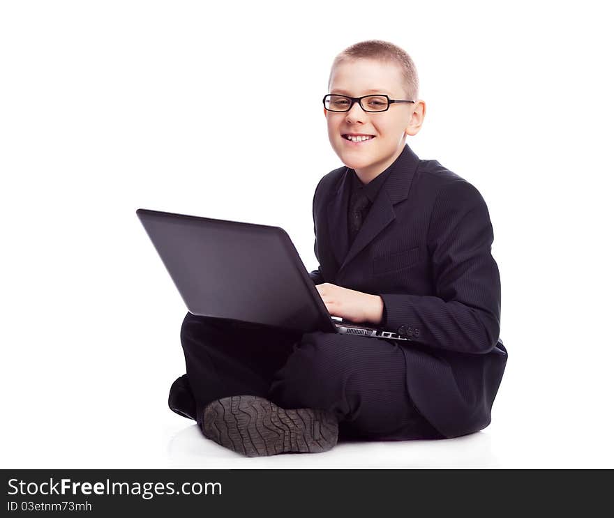 Ten year old blond boy wearing a costume with a laptop. Ten year old blond boy wearing a costume with a laptop