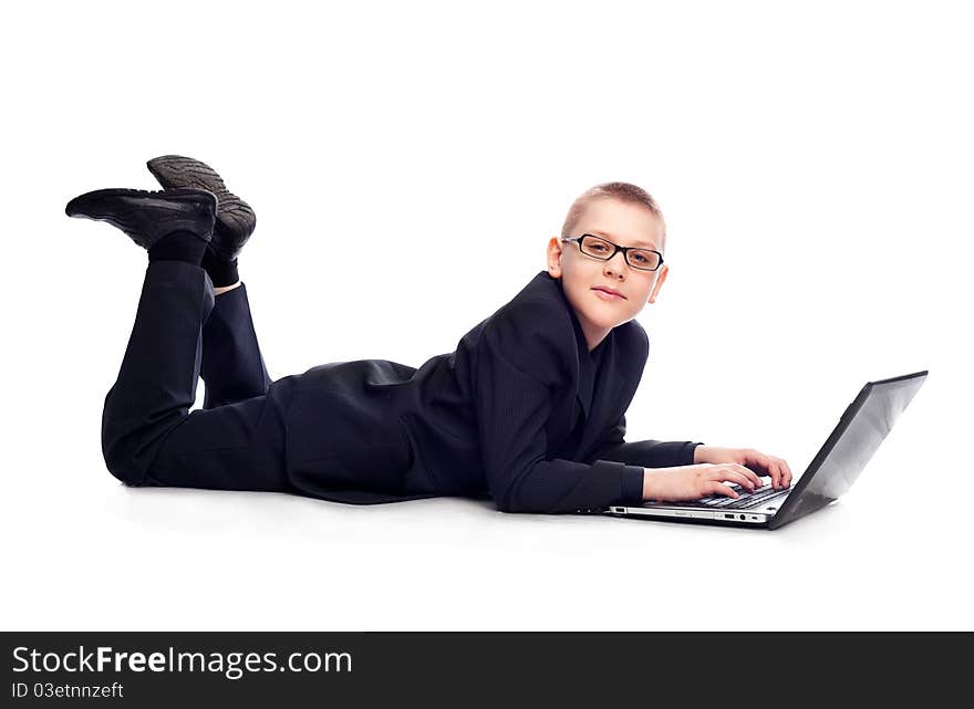 Ten year old blond boy wearing a costume with a laptop. Ten year old blond boy wearing a costume with a laptop