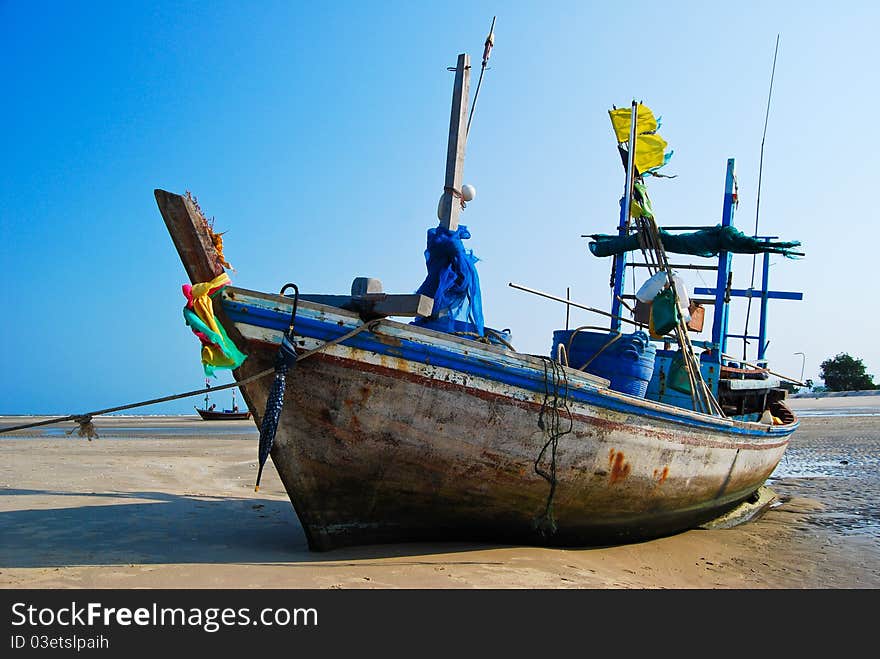 Fisherman boat on the sea shore , with bright blue sky background